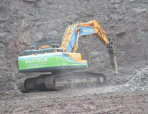 Excavator mounted Furukawa FXJ hydraulic breaker working in a quarry site